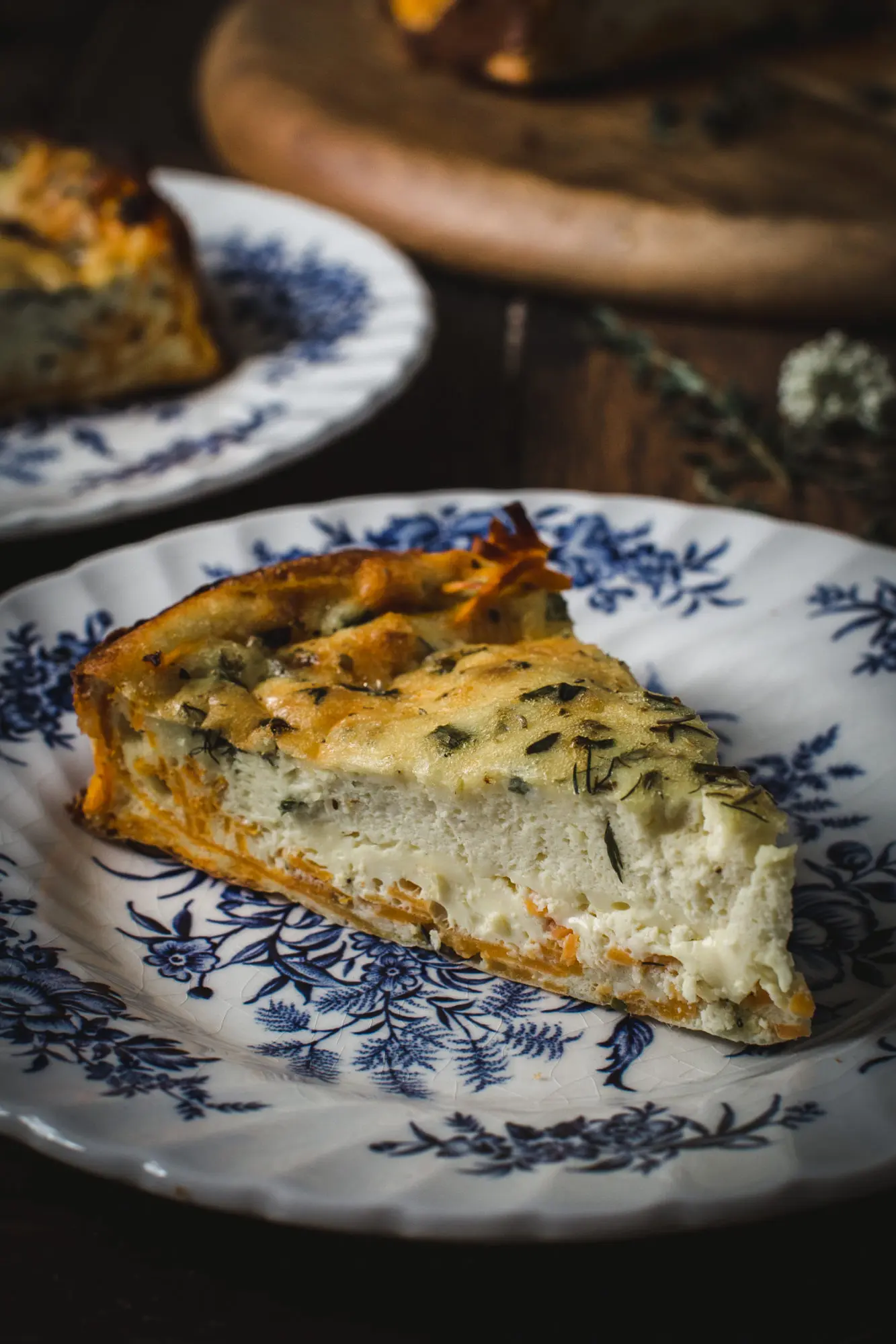 Goat Cheese and Herb Quick with Sweet Potato Crust slice on white china with blue floral