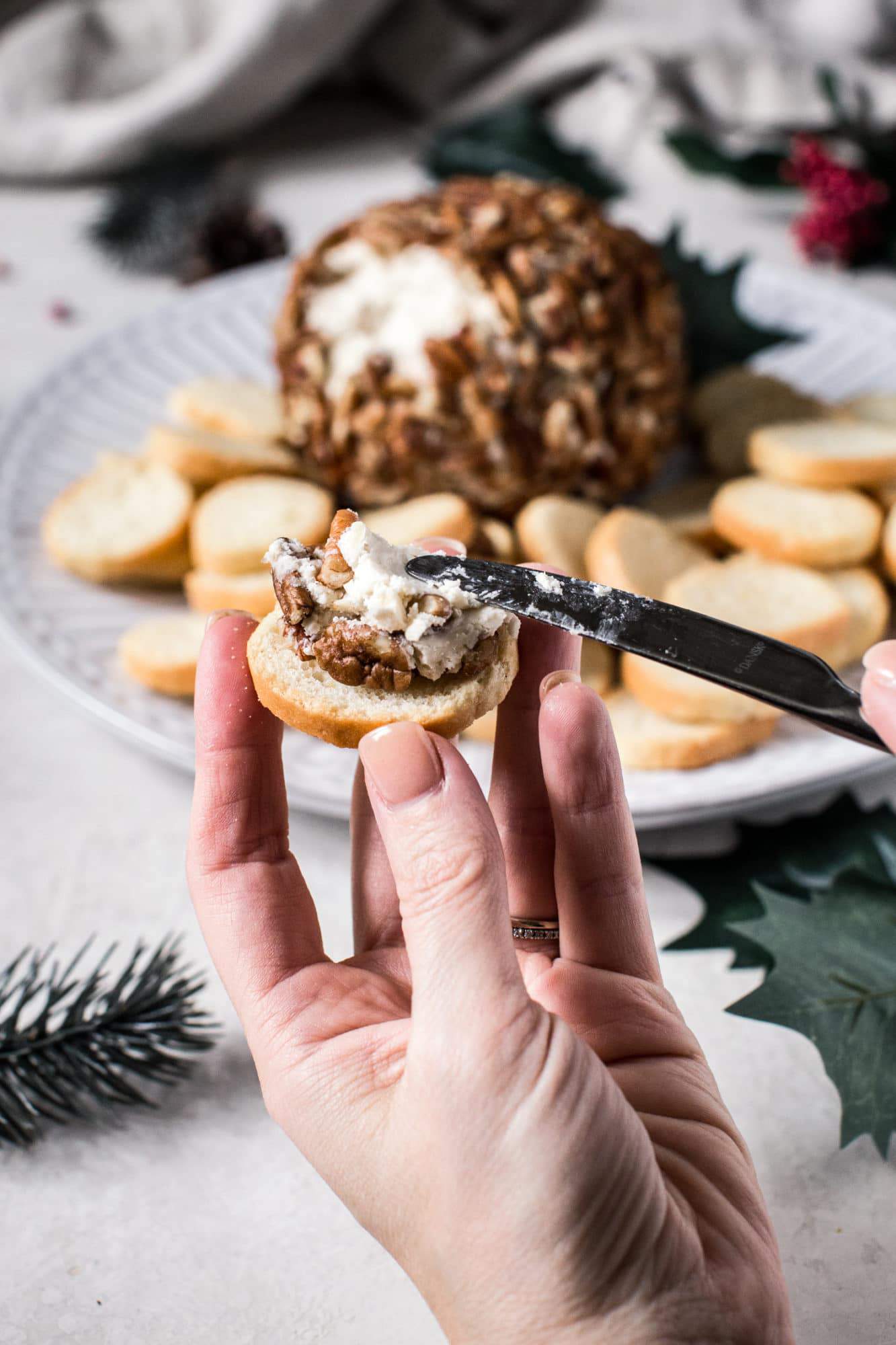 cheese being spread on a crostini