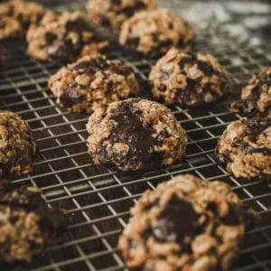 Oatmeal cookies with chocolate chips on wire rack.