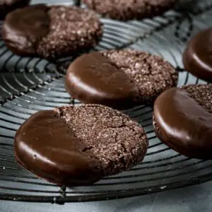 Chocolate dipped soft ginger cookies on a wire rack.