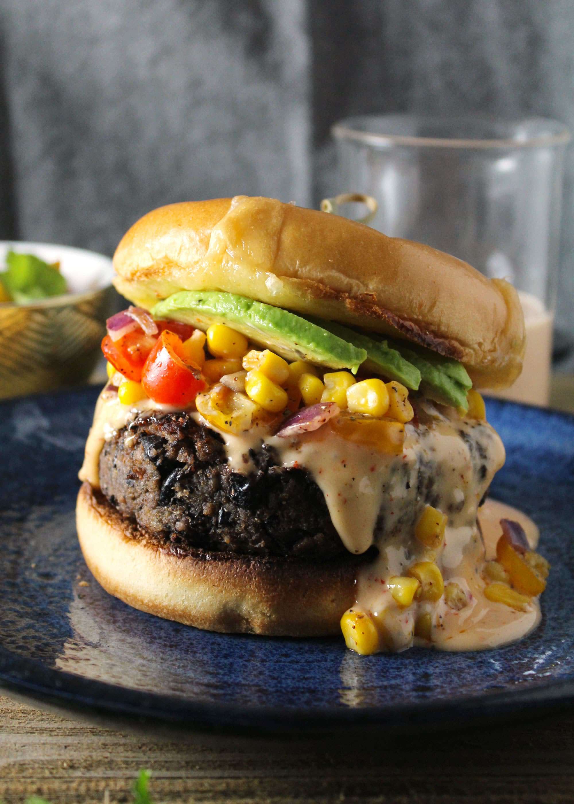 Southwest black bean burger topped with corn salsa and avocado.