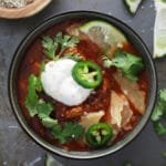 Sweet potato turkey chili in a bowl topped with cilantro and lime wedges.
