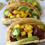 Jamaican jerk chicken tacos loaded with avocado and mango.
