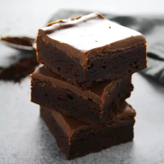 Secret ingredient fudge brownies stacked on top of each other.