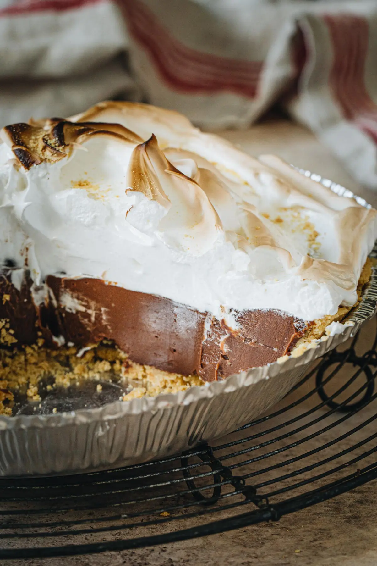 No-bake s'mores pie topped with marshmallow meringue in a metal pie plate.