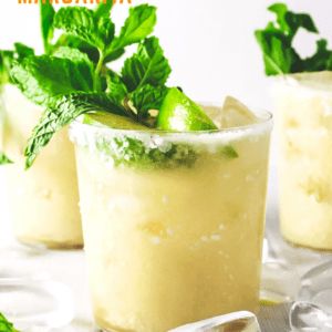 Three pineapple coconut margaritas topped with lime and mint leaf.