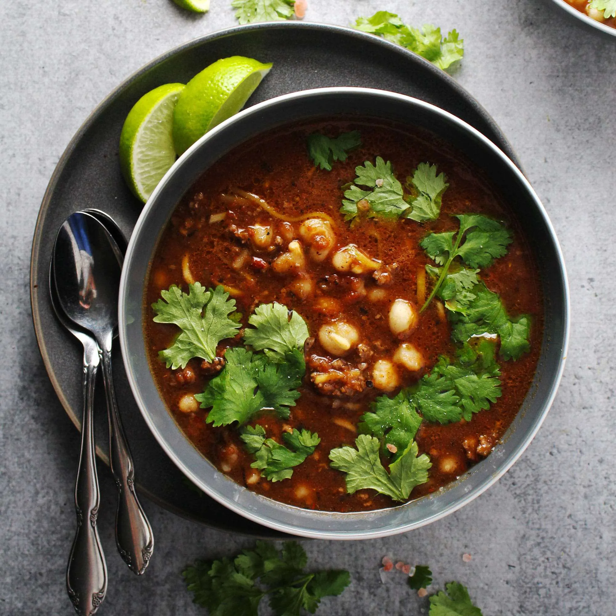 Picture of pozole rojo stew in gray bowl.