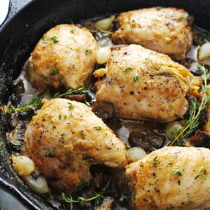 Skillet chicken in mushroom cream sauce sitting in an iron skillet.