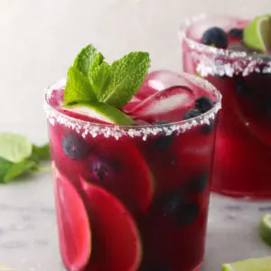 Blueberry mint margarita topped with fresh mint leaves.