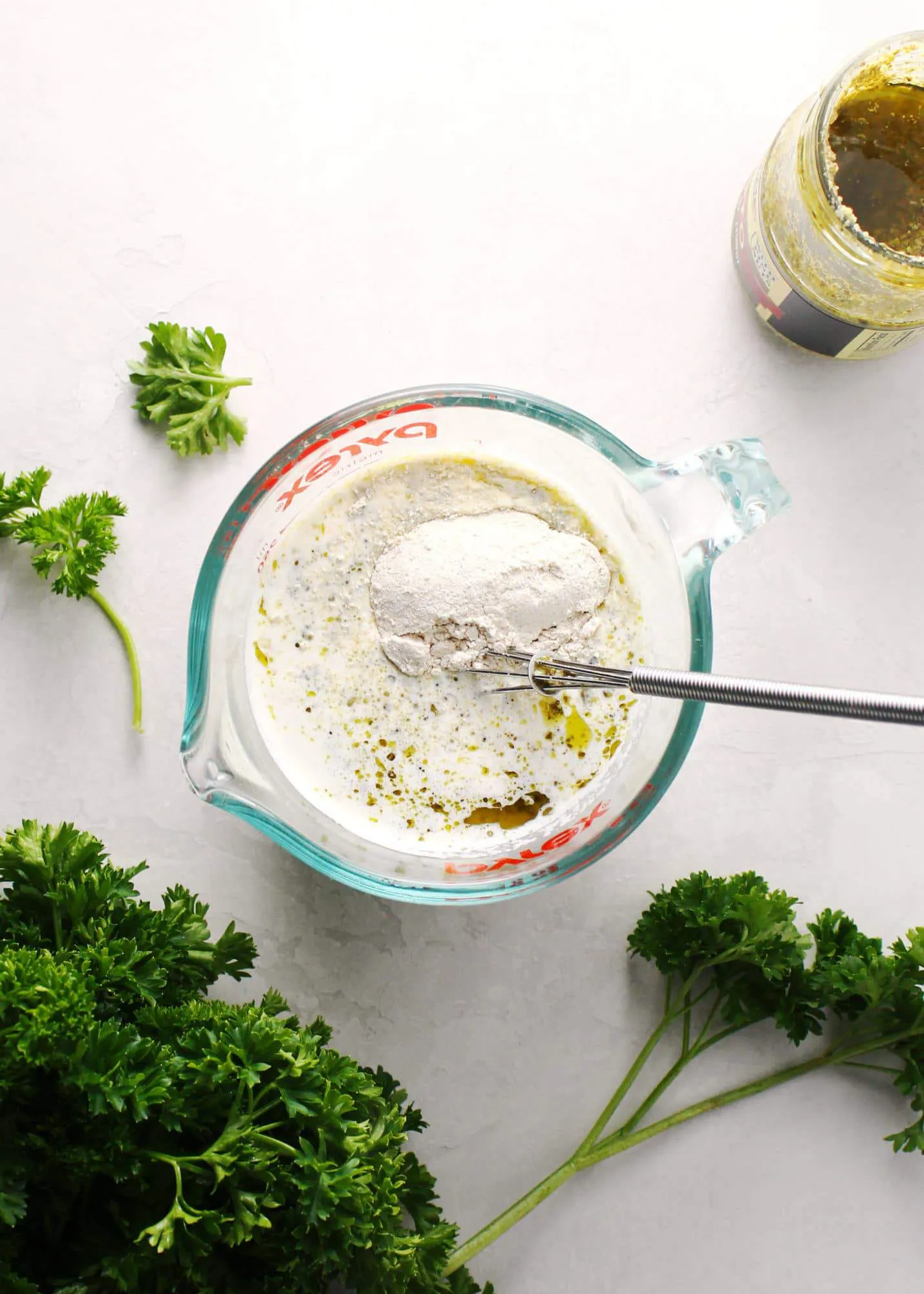 Cream Sauce for pesto chicken in a measuring cup.