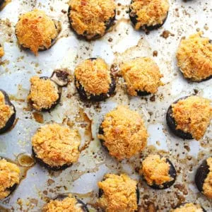 Mushrooms stuffed with a pimento cheese mixture on a baking sheet.