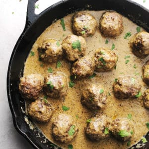 Swedish meatballs in sauce in a black cast iron skillet.