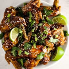 Crispy honey sriracha wings topped with green onions and sesame seeds.