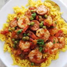 sausage and shrimp with yellow rice on a white plate