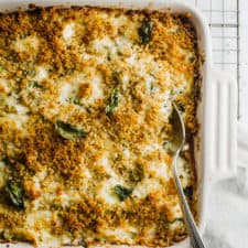 Chicken Alfredo Cauliflower Bake in a square casserole dish with a silver spoon inserted.