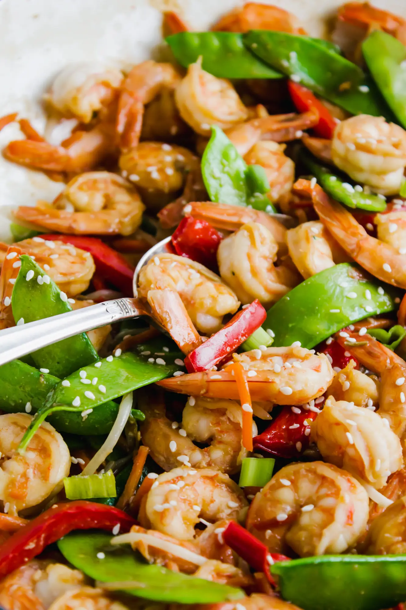 close up of shrimp stir-fry with silver spoon