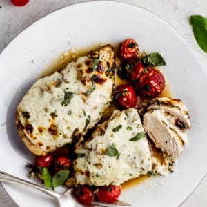 balsamic chicken covered in mozzarella cheese with cherry tomatoes