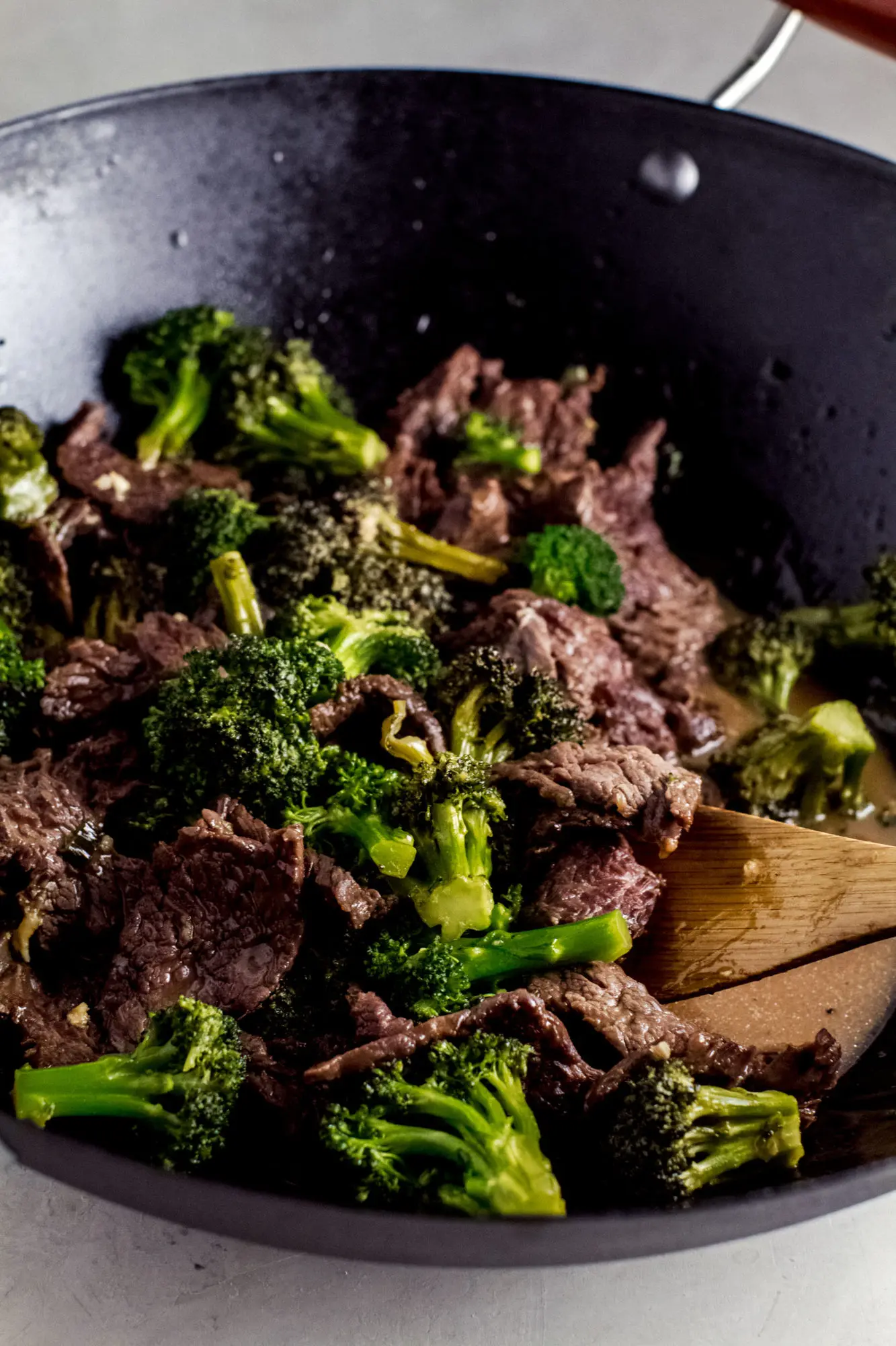 Beef and broccoli stir fry in a black wok.