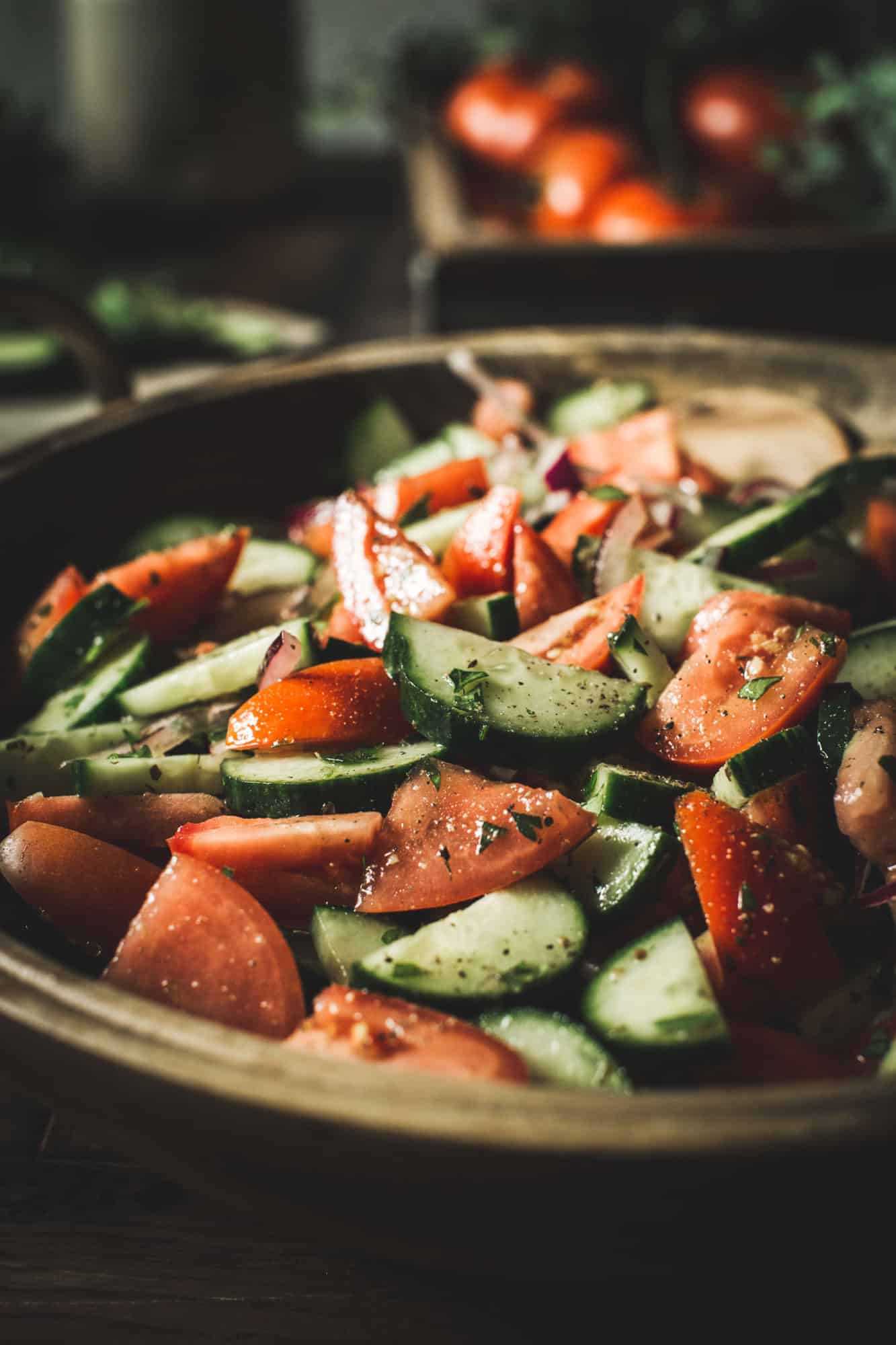 Italian cucumber, onion, and tomato salad in a large wooden bowl.