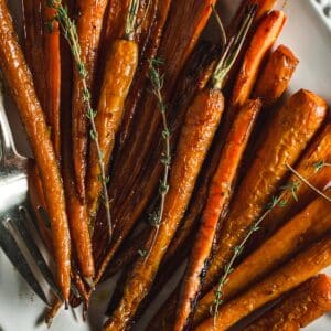 Roasted carrots with honey glaze on a white platter.
