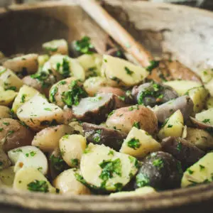 Herbed potato salad in a wooden bowl.