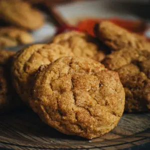 Soft pumpkin cookies on a wooden plate.
