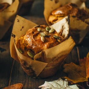 Vegan pumpkin muffin with pumpkin seeds on top.