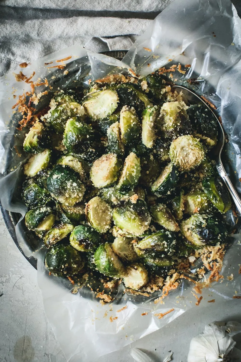 Close up of roasted Brussel sprouts covered with shredded cheese.