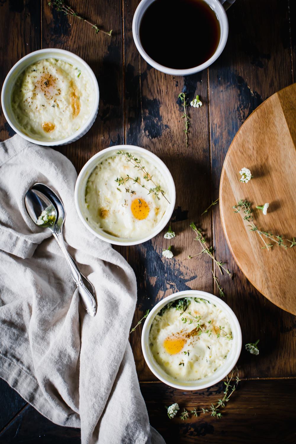 baked eggs in ramekin with coffee and linen on wooden table