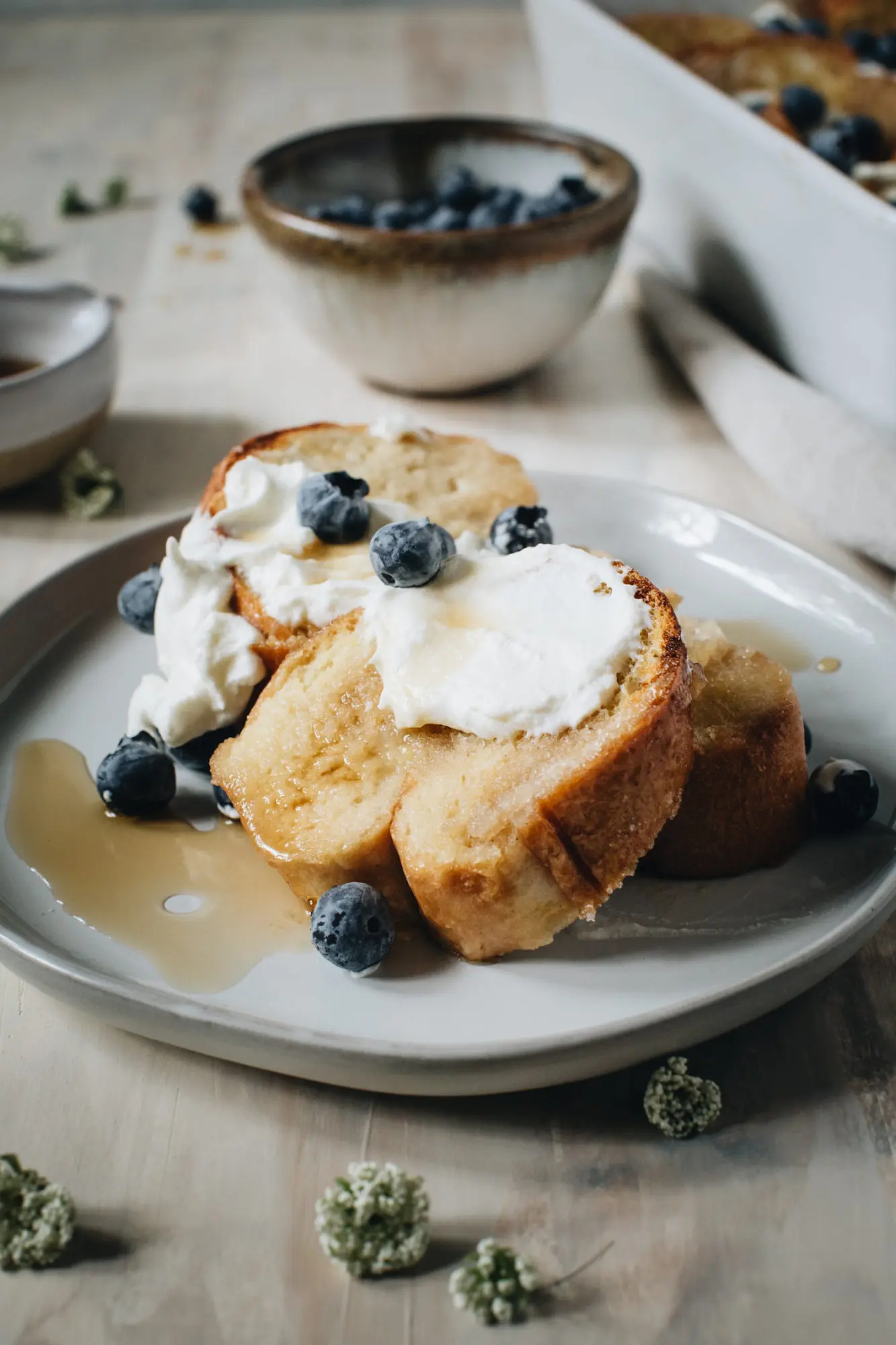 creme brulee french toast with whipped cream and blueberries on gray plate