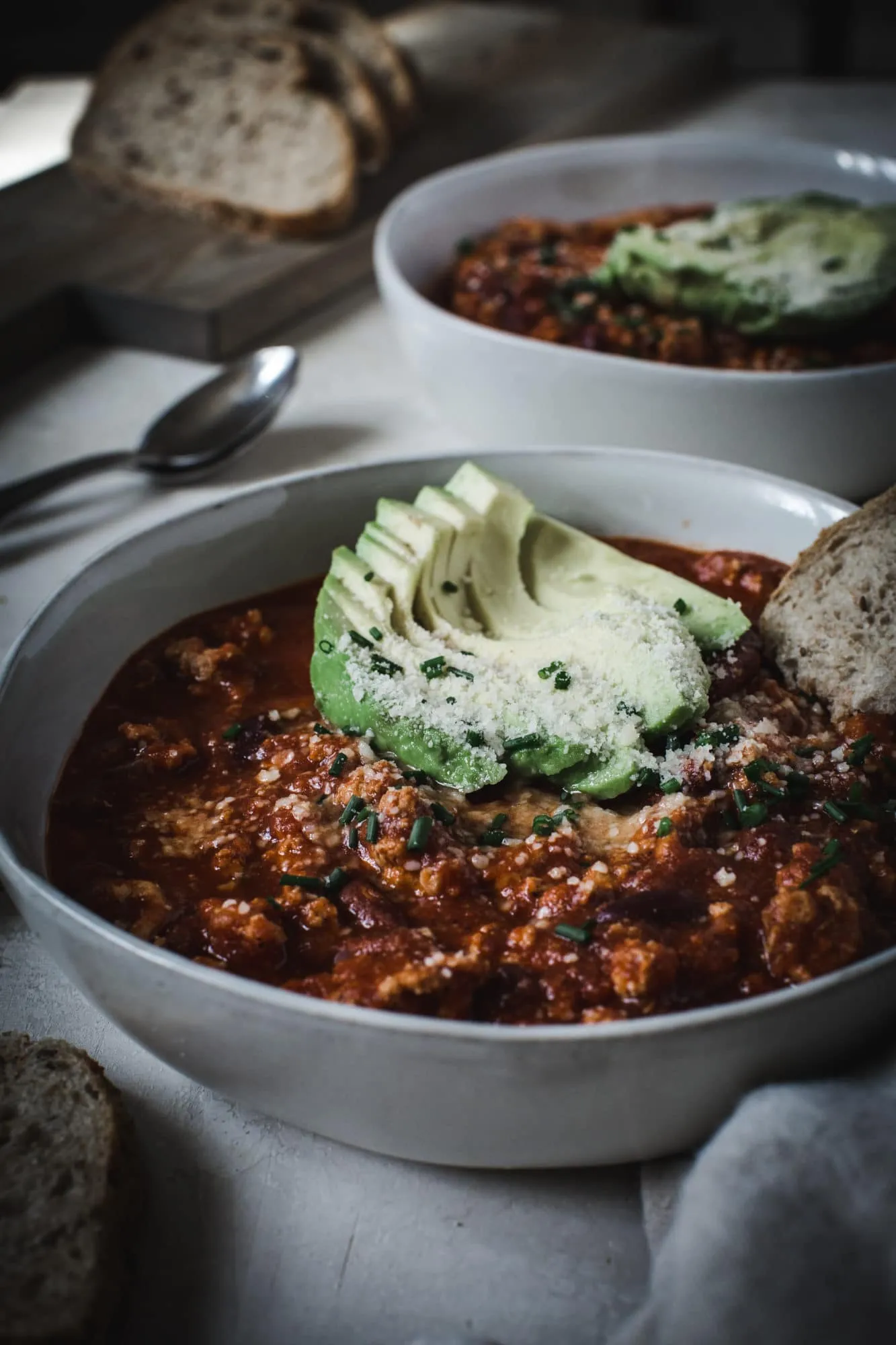 healthy turkey chili with avocado and bread toppings