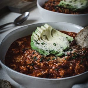 healthy turkey chili with avocado and bread toppings
