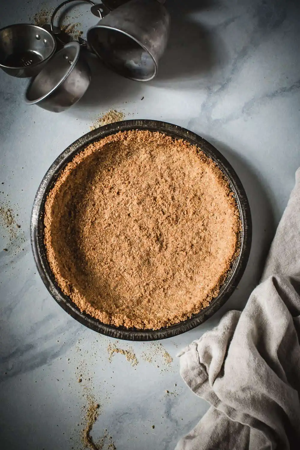 graham cracker crust in pie tin on marble counter