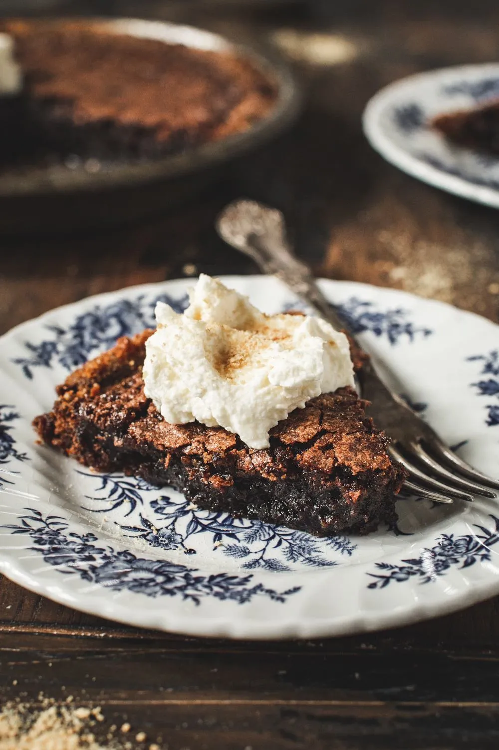 slice of fudge pie with whipped cream on a blue and white china plate