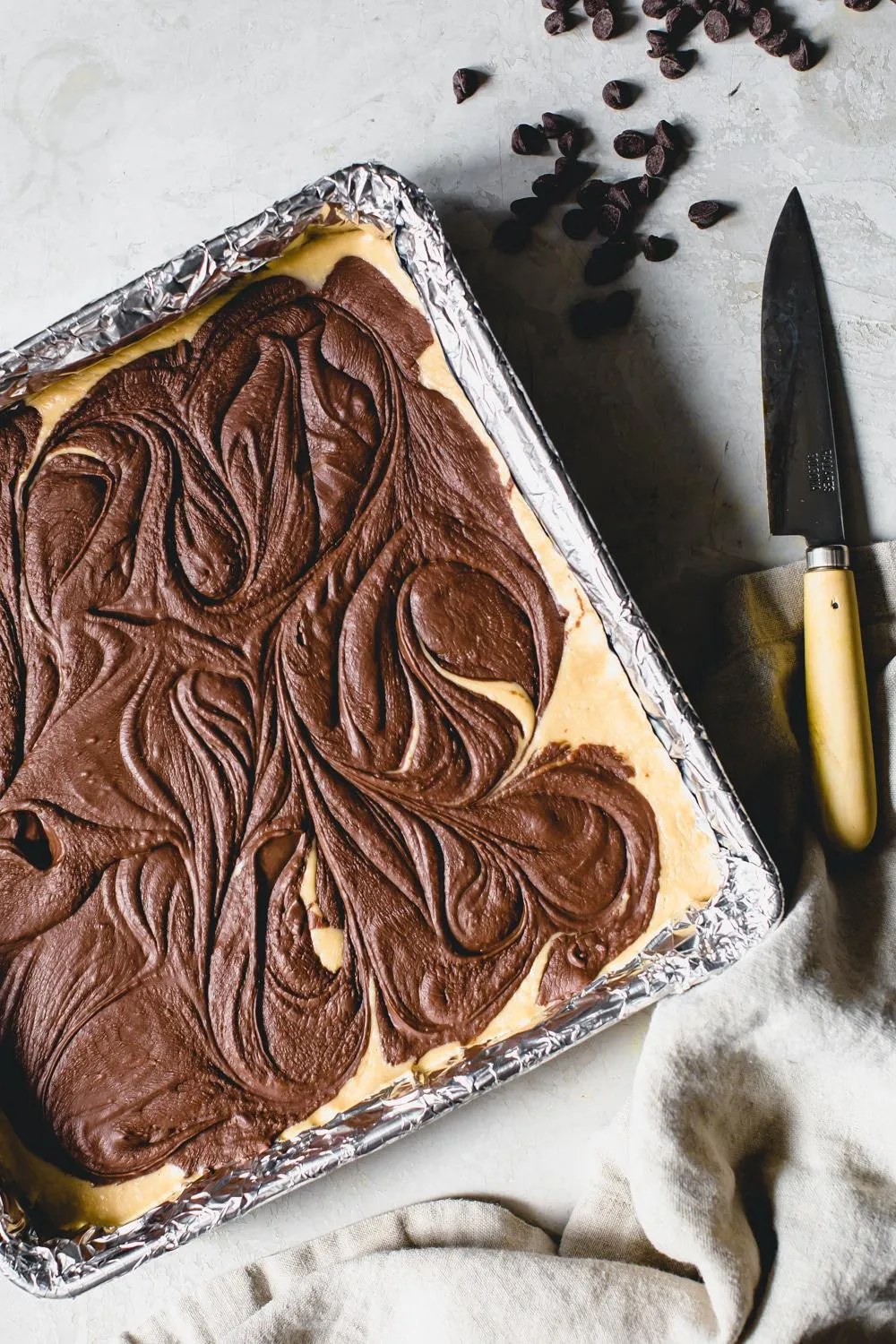 un-cut fudge in a foil wrapped pan with knife