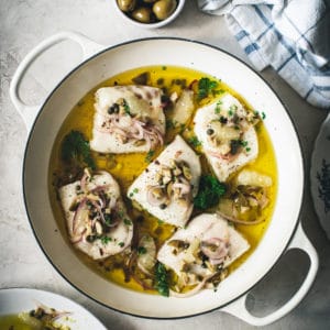 lemon baked cod in a white skillet with relish
