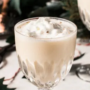 Eggnog martini topped with whipped cream in a glass.