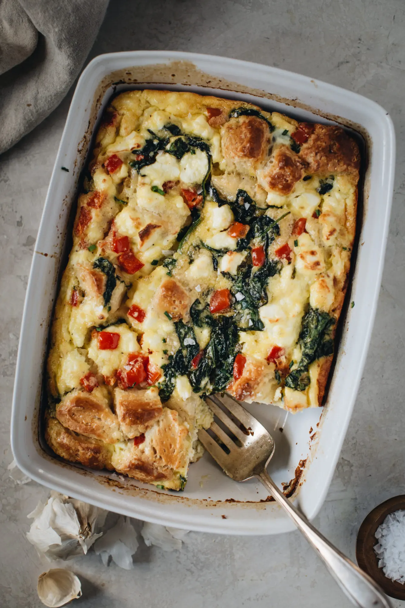 breakfast casserole with serving fork in white dish