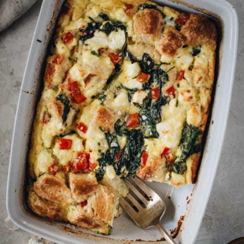 breakfast casserole with serving fork in white dish