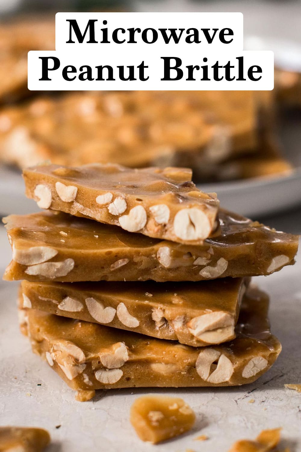 Stack of microwave peanut brittle with a plate full behind it.