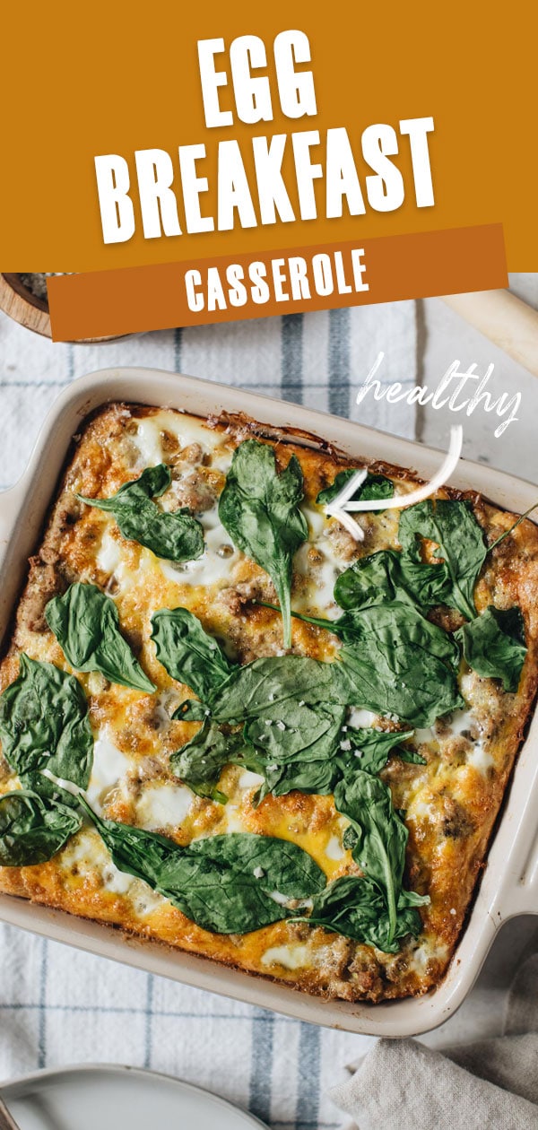 Egg breakfast casserole in a square baking dish topped with spinach.