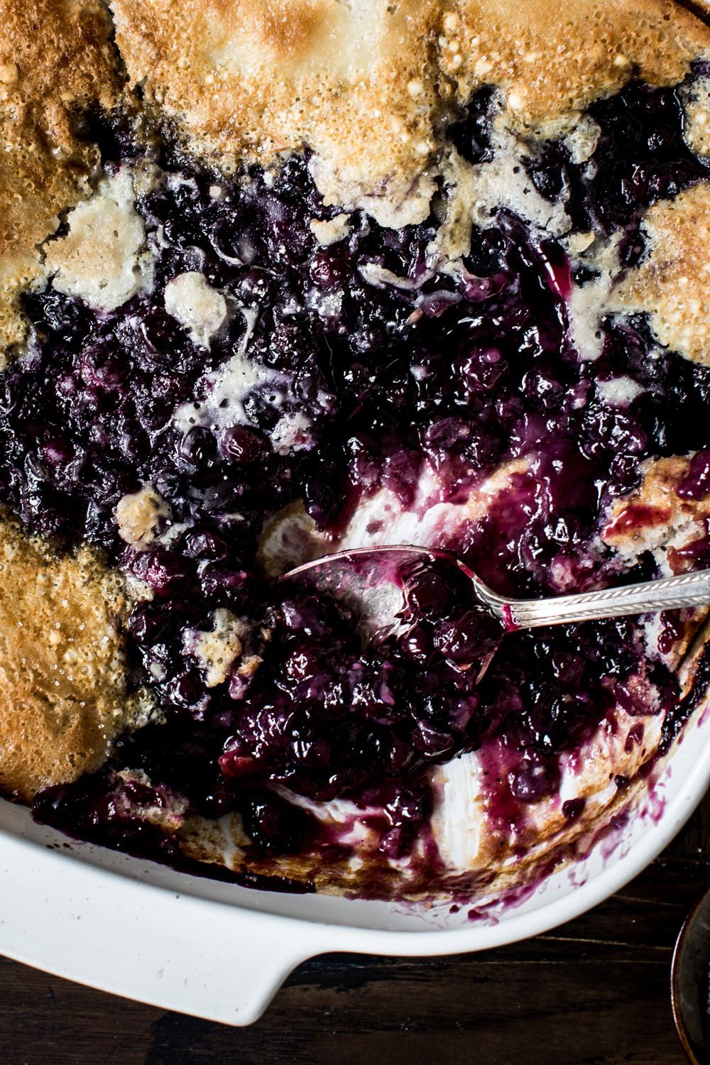 Serving spoon in blueberry cobbler.