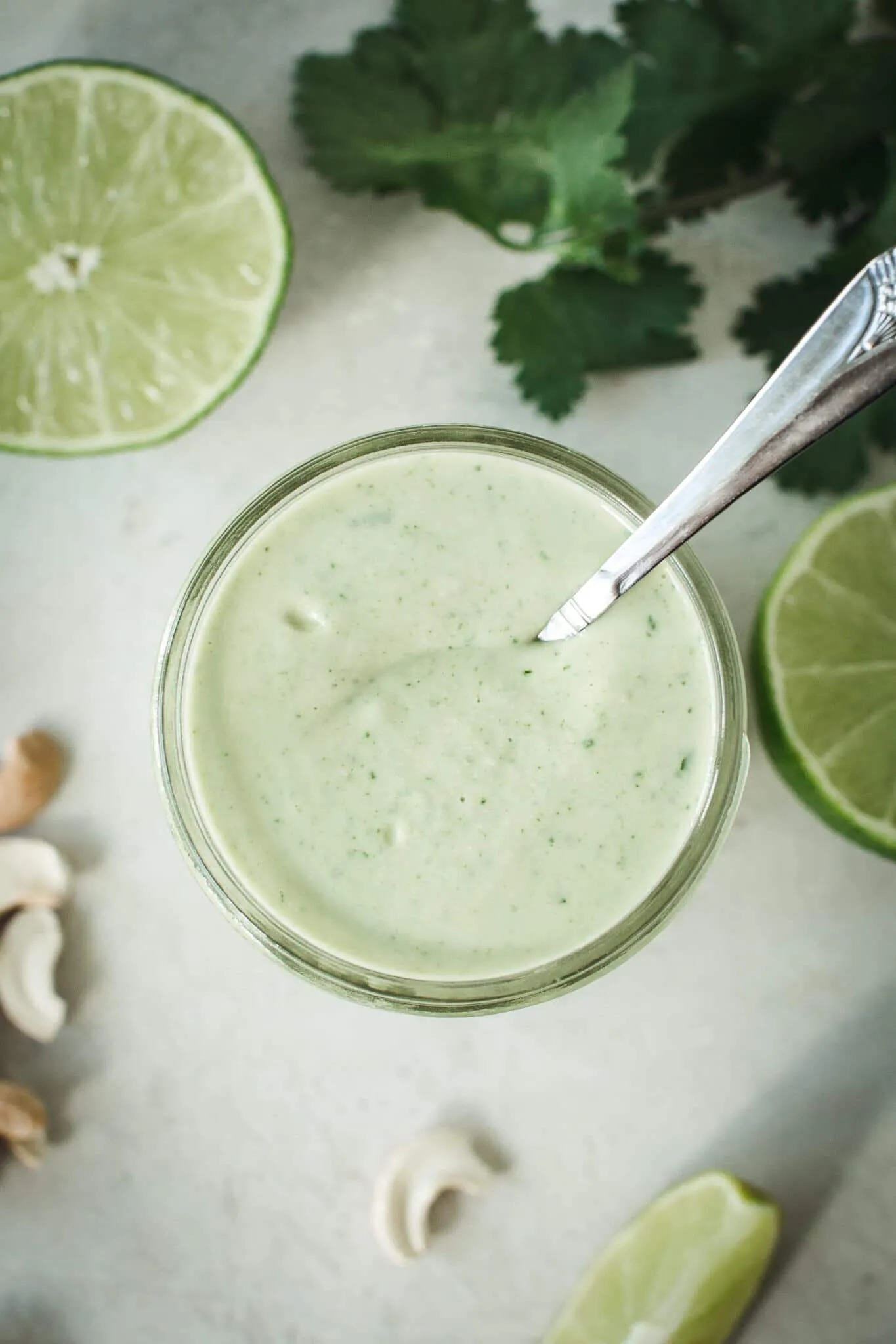 Vegan lime crema in a jar with a spoon.