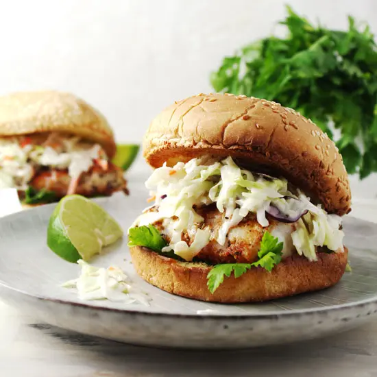 Blackened fish sandwich topped with coleslaw on a bun.