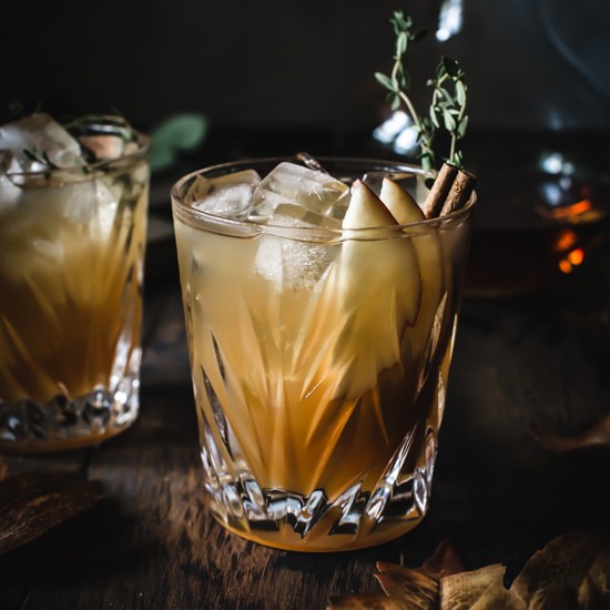 Apple cider cocktail in a high ball glass with ice.