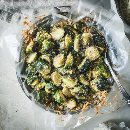 Roasted brussel sprouts in a metal tin with parchment.