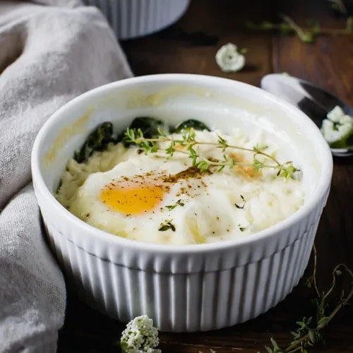 Baked eggs in a white ramekin dish.