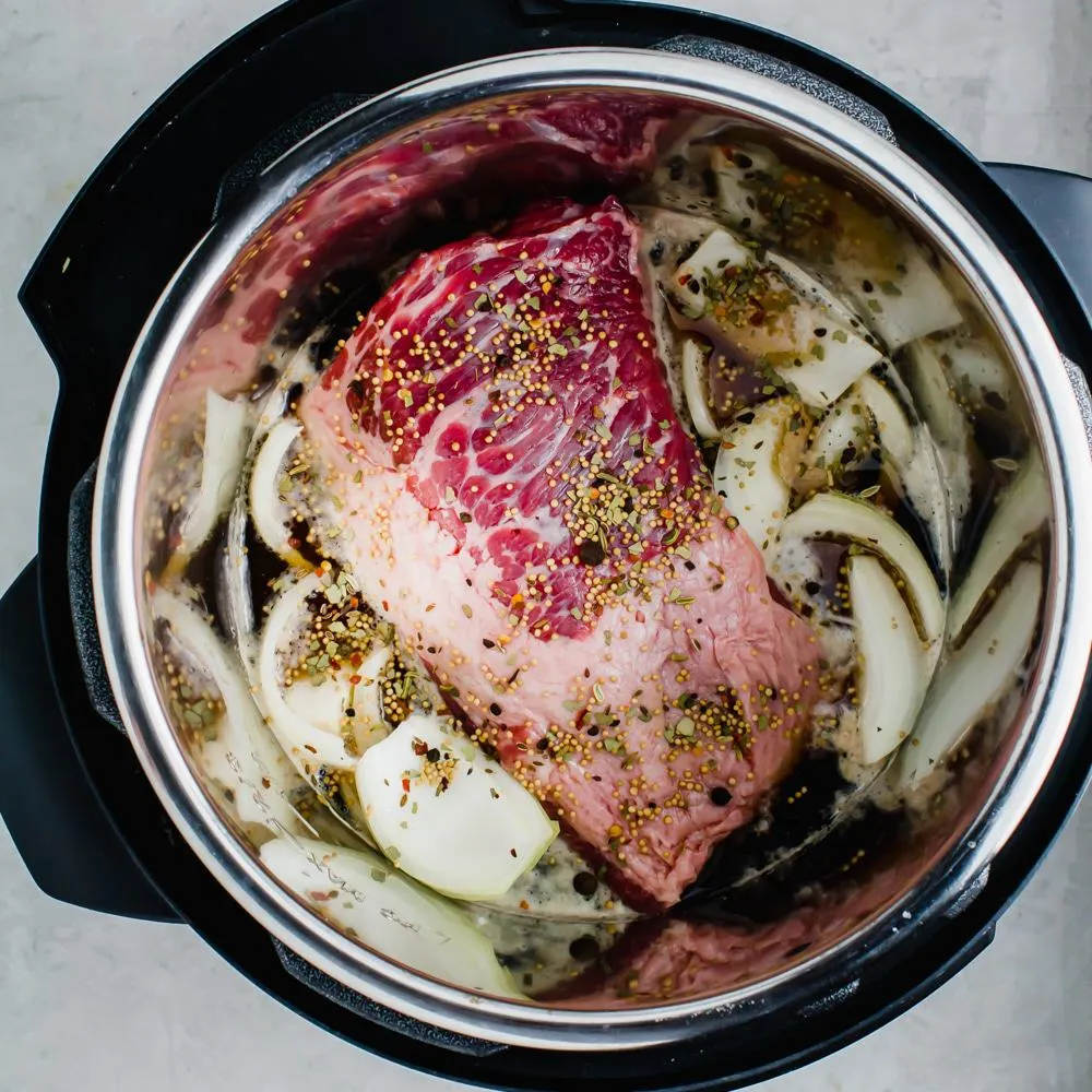 Instant pot with corned beef ingredients inside.