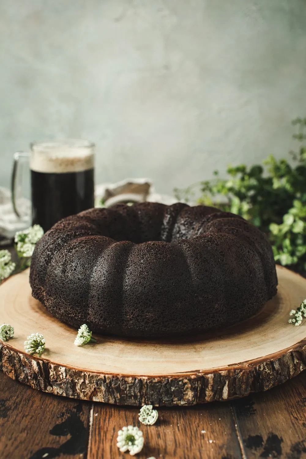 Chocolate bundt cake on a tree stump board.