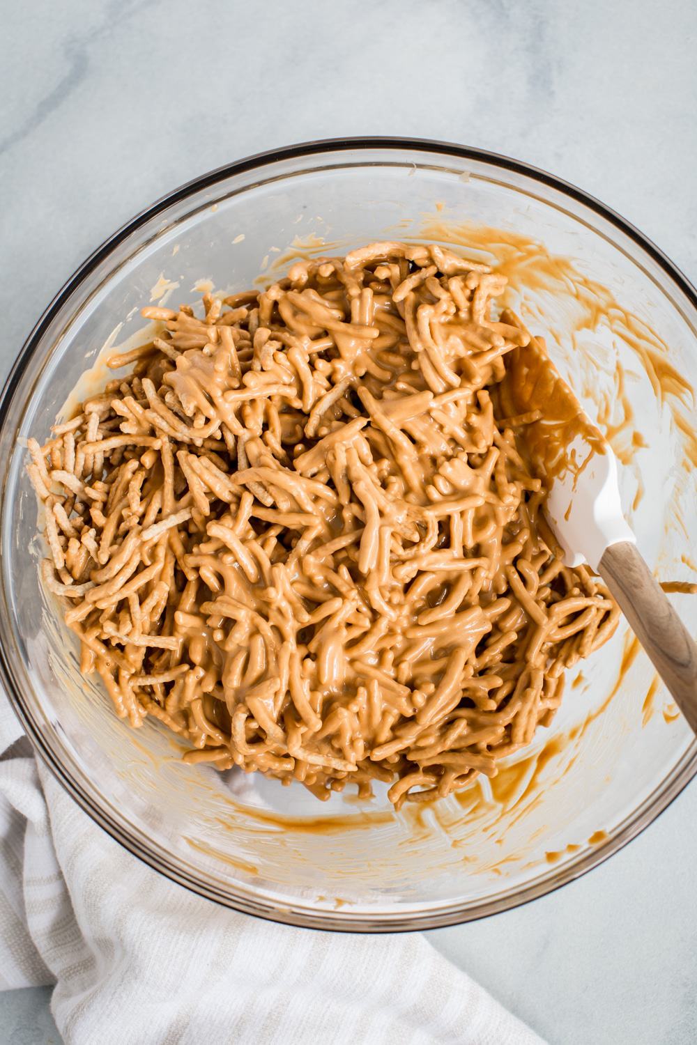 Nouilles chow mein dans le mélange au caramel dans un bol en verre.